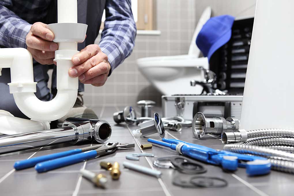 Plumber assembling parts in the bathroom 