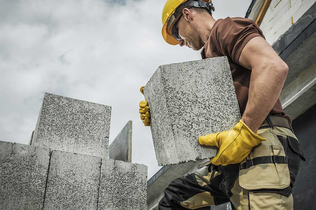 Construction worker moving concrete blocks
