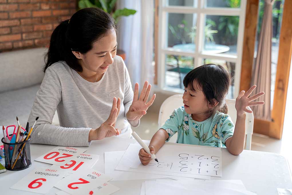 Mother teaching basic math to her daughter at home